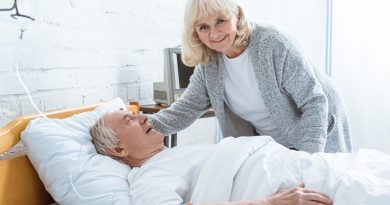 Mujer mayor sonriendo atendiendo a paciente en cama