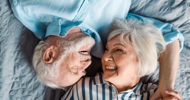 pareja de adultos mayores recostados en la cama felices y sonrientes