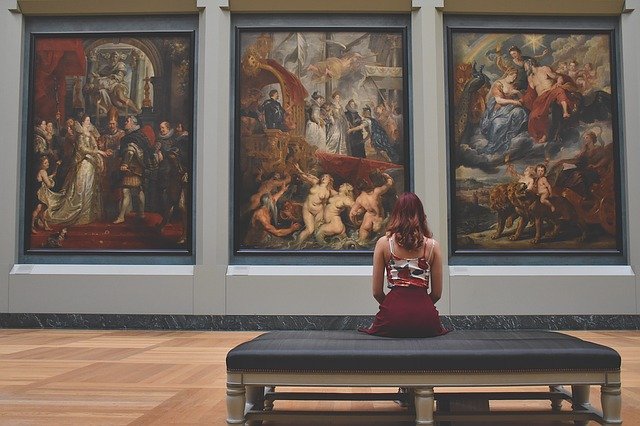 Mujer en un museo apreciando una pintura
